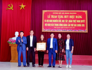 Đồng chí Hồ Nam - UV BTV Huyện ủy, Trưởng Ban Dân vận, CT UBMMTQ huyện trao huy hiệu 55 tuổi Đảng cho đảng viên Nguyễn Thị Đông - đảng viên chi bộ Trung Tiến